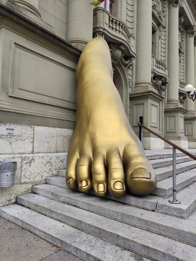 Un pied doré sur les marches du monument