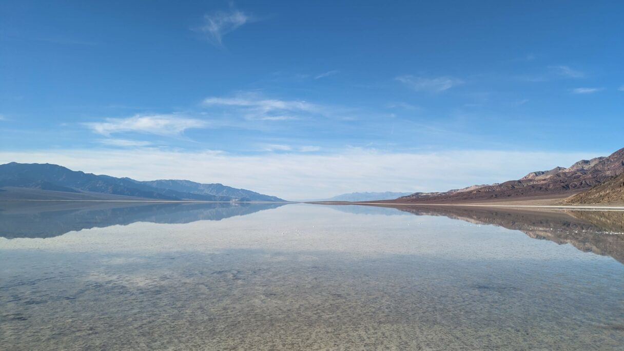 Les montagnes de la vallée de la mort se réflètent dans l'eau de Badwater Basin.