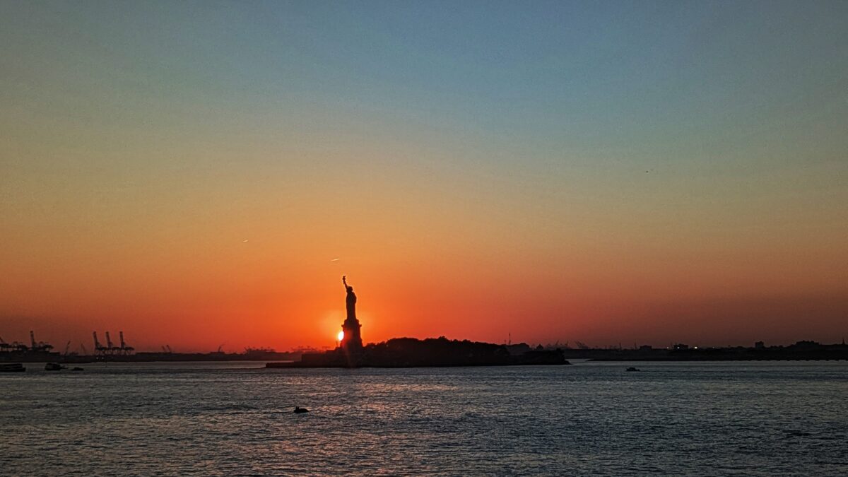 Silhouette de la statue de la liberté devant le soleil couchant