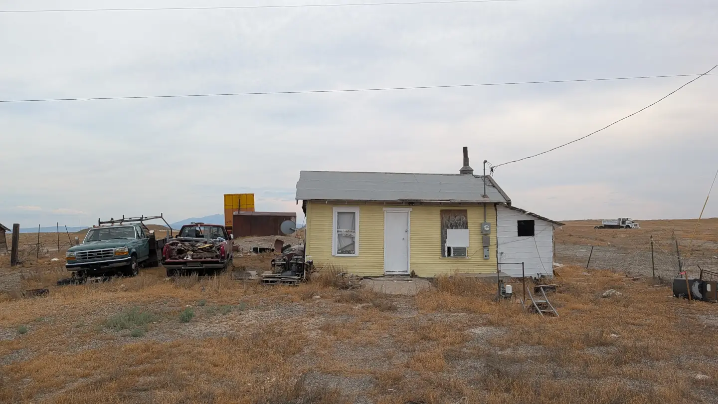 Une vieille maison abandonnée et des carcasses de voitures à Cisco, Utah